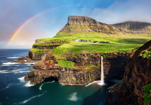 Múlafossur Waterfall cascading into the ocean beside the village of Gásadalur in the Faroe Islands