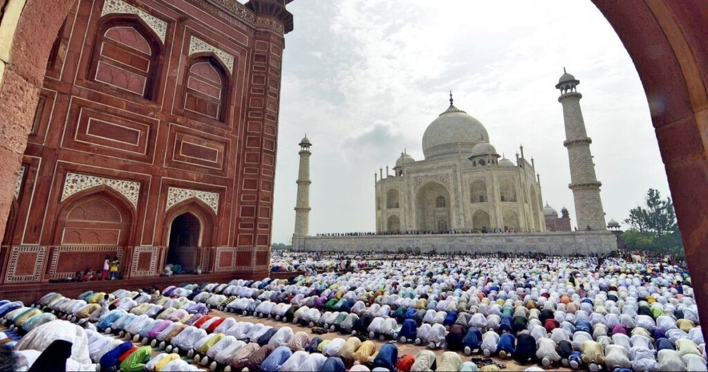 praying inside the mosque area of the Taj Mahal, surrounded by intricate Mughal architecture.
