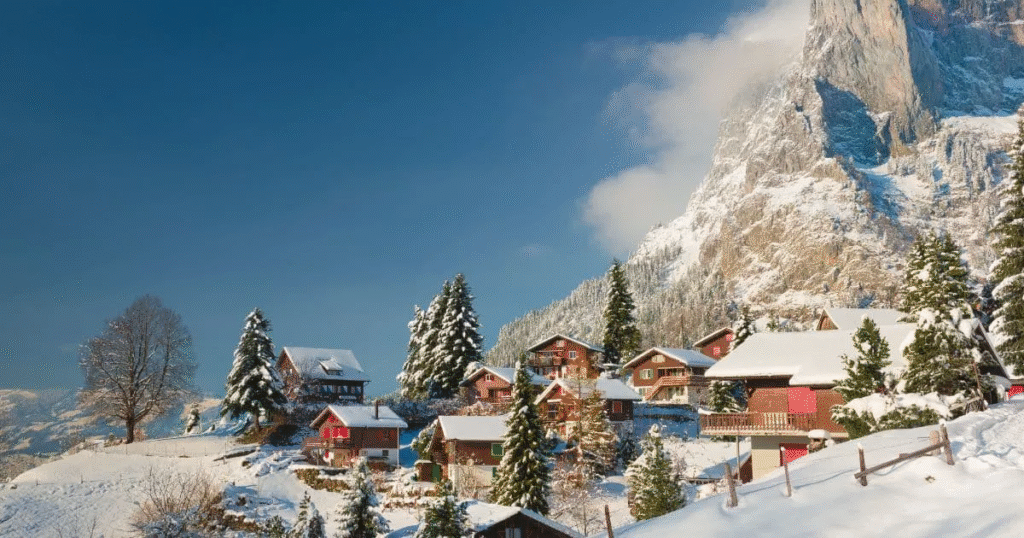Snow-covered peaks of the Swiss Alps under a clear blue sky.
