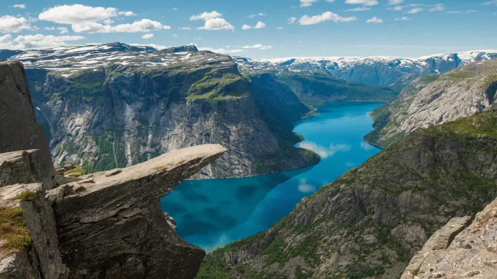the edge of Trolltunga rock ledge in Norway with dramatic mountain and fjord views
