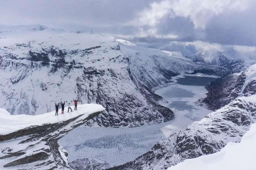 Snow-covered mountain peaks near Trolltunga, with pristine white landscapes and a clear blue sky