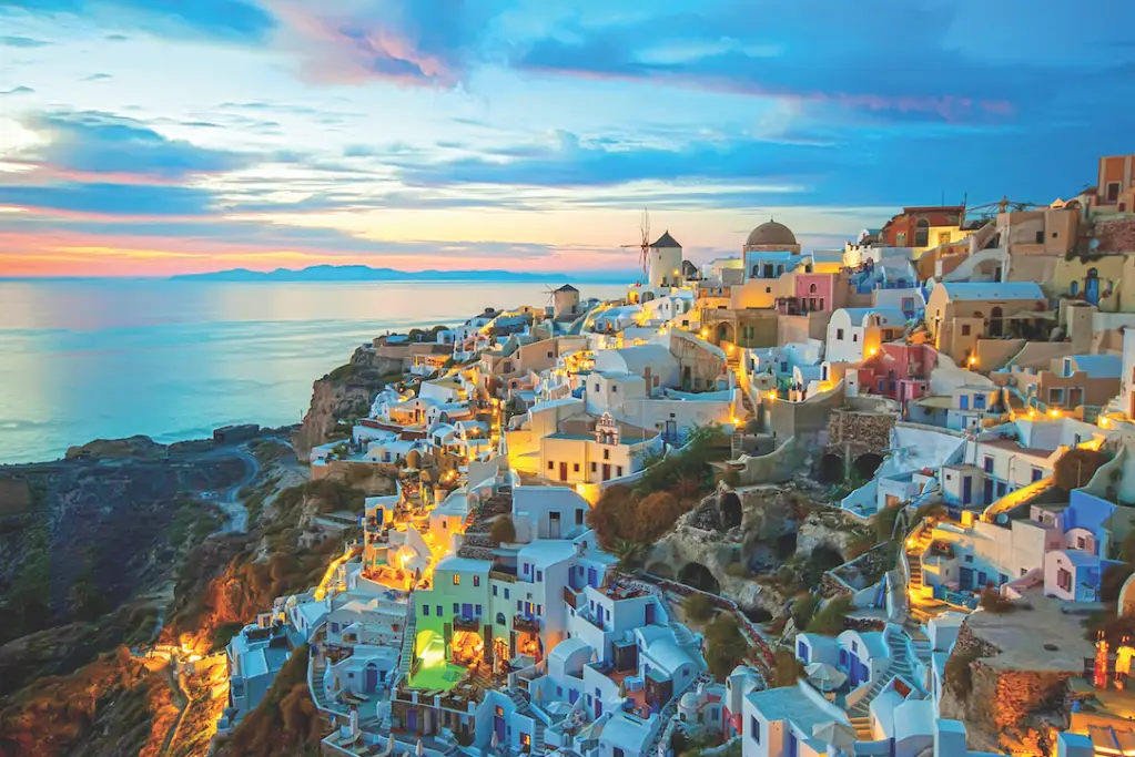 White-washed buildings on the cliffs of Santorini, Greece at sunset