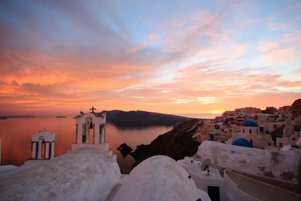 Sunset over the Aegean Sea with white buildings in Santorini, Greece