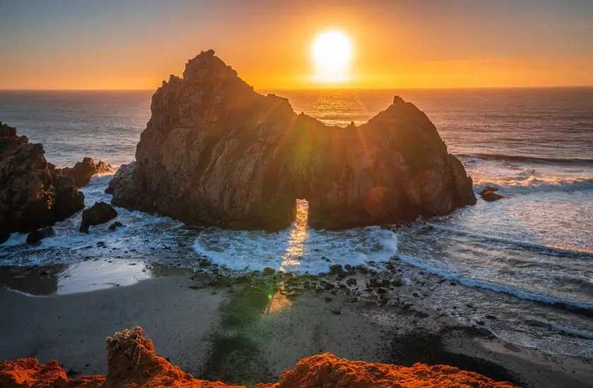  Waves crashing through the rock arch at Pfeiffer Beach in Big Sur at sunset